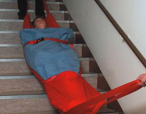 Emergency evacuation sledge in use on stairs for patient safety - Kirby Fire Safety